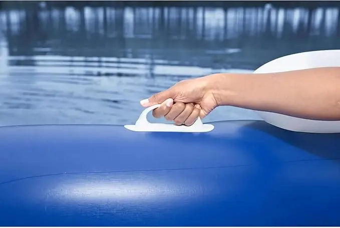 Hand using a white suction cup on a blue surface with water in the background
