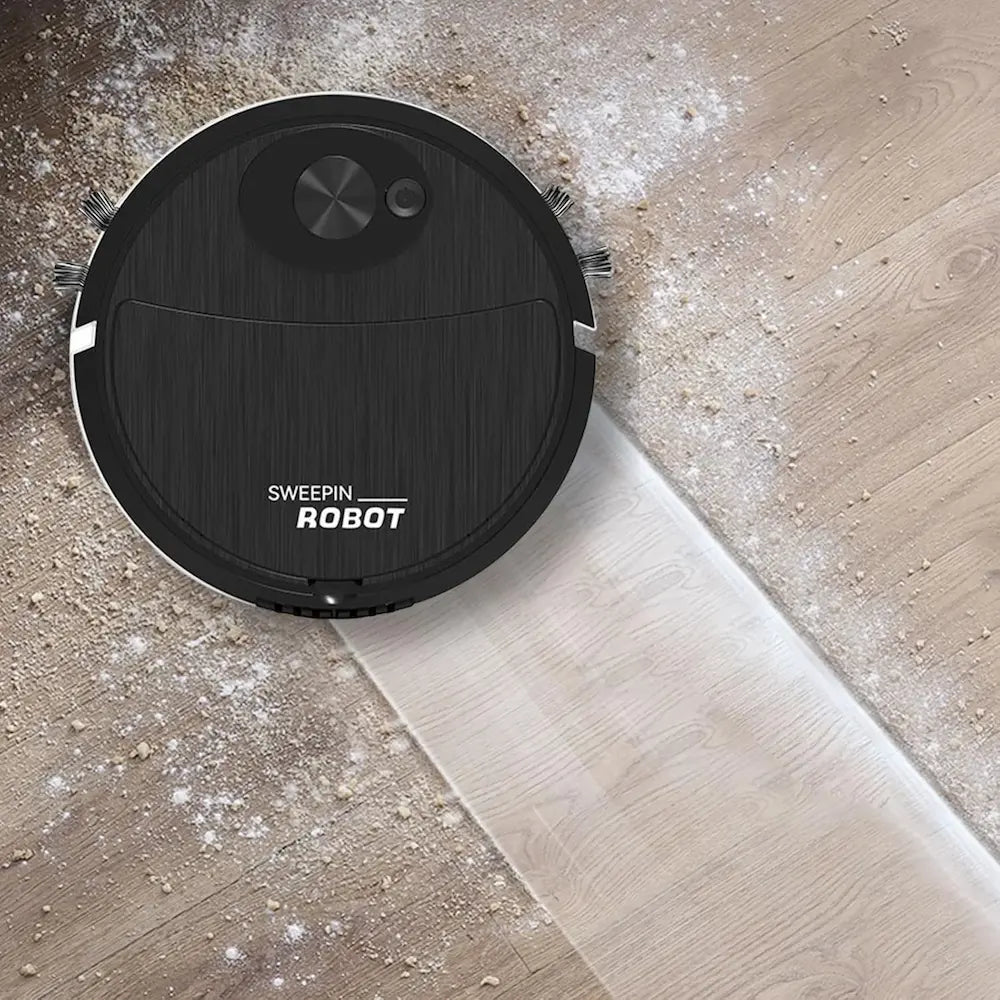 Robotic vacuum cleaner cleaning a wooden floor with visible dust.