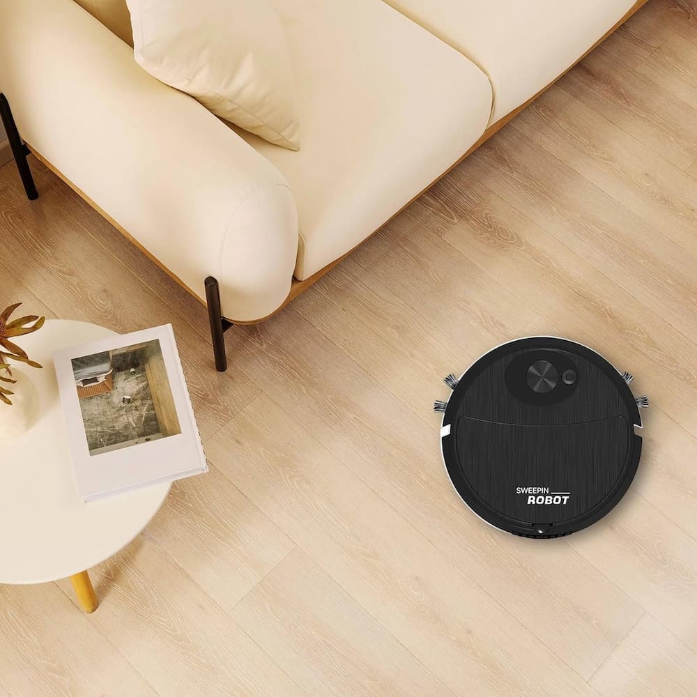 Robotic vacuum cleaner on a wooden floor in a living room setting