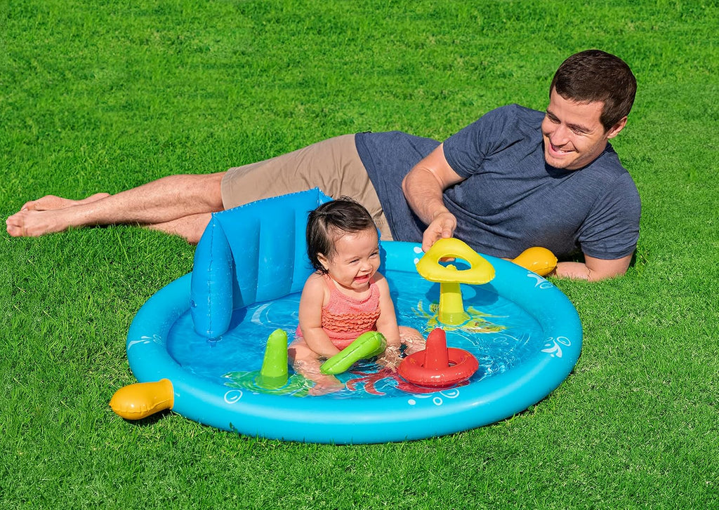 Man and child playing in an inflatable pool on grass